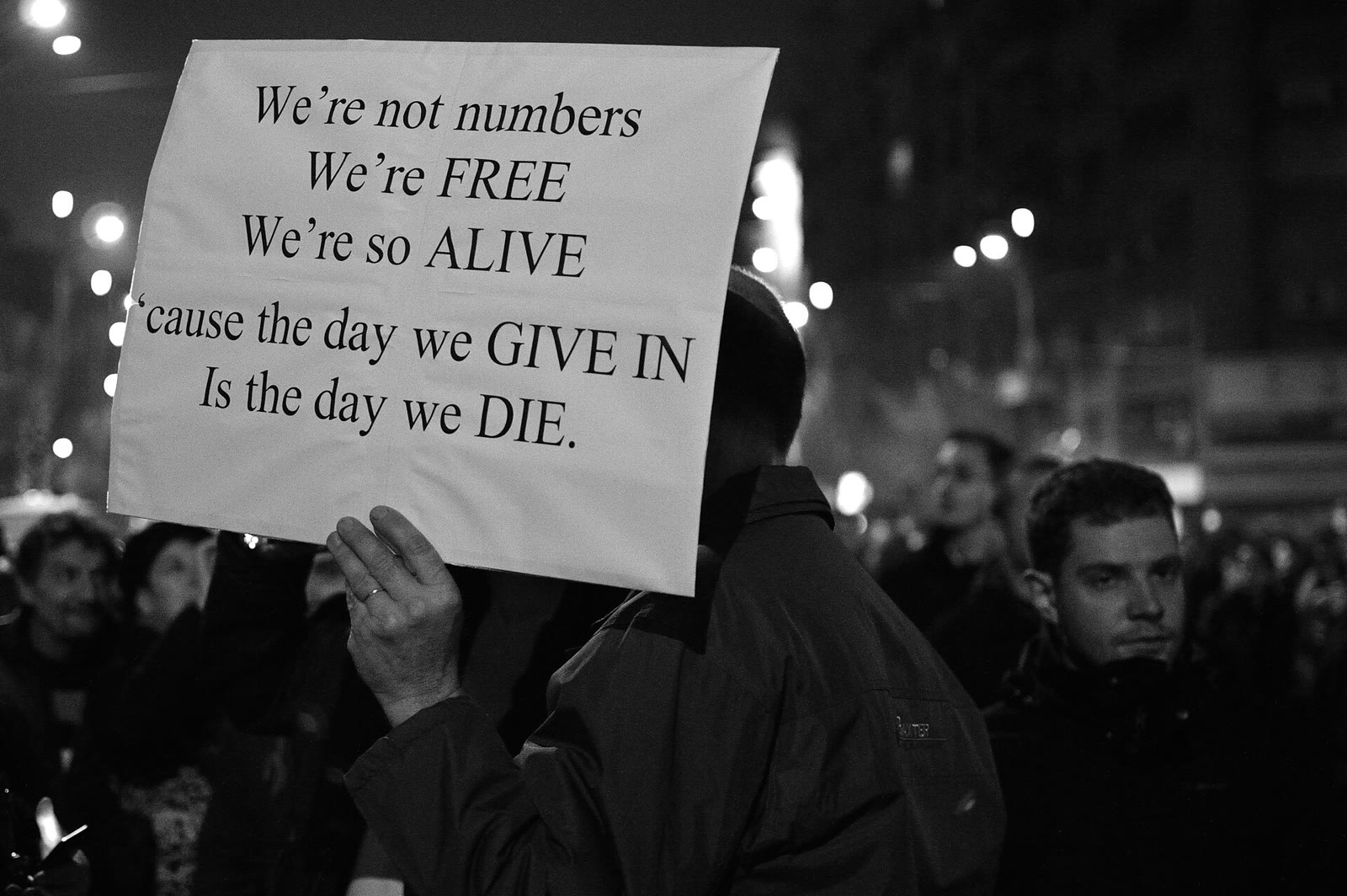 Participant la protestele de după incendiul Colectiv ținând mesajul We're not numbers, we're free